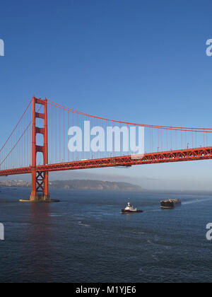 tugboat pulling tanker under Golden Gate Bridge in San Francisco California Stock Photo