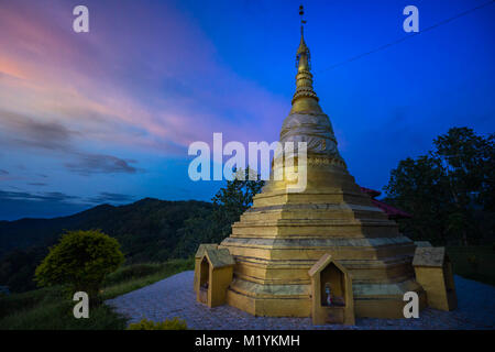 Gold pagoda over Salween river on Mae Hong Son province between Thailand and Myanmar border in twilight. Stock Photo