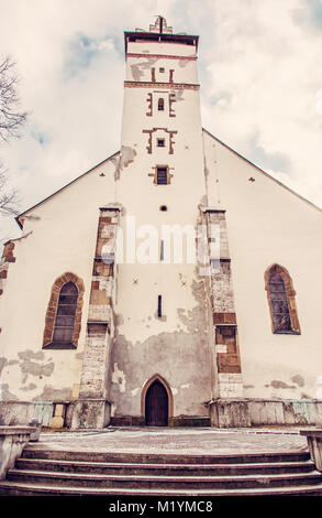 Basilica of the Holy Cross in Kezmarok city, Slovak republic. Religious architecture. Travel destination. Red photo filter. Stock Photo