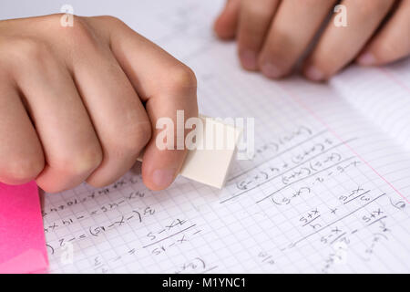 Hand with White Ruber Eraser on White Paper. Mistake Erase Concept. Stock Photo