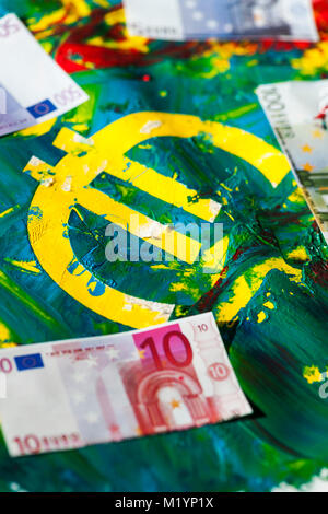 Euro sign in colorful pasty mixed acrylic color with applied euro banknotes. Stock Photo