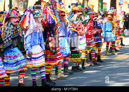 Horizontal photo of a Carnival scene, dancers wearing a traditional mexican folk costume and mask rich in color Stock Photo