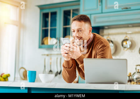 Happy nice man using his smartphone Stock Photo