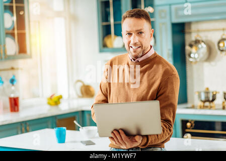 Nice bearded man holding his device Stock Photo