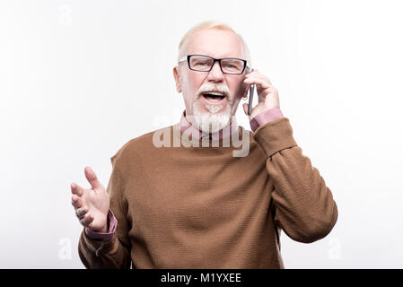 Elderly man having emotional conversation on the phone Stock Photo