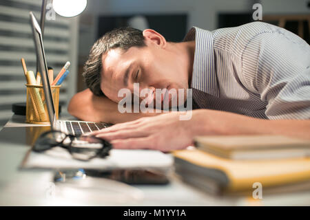 Skillful male employee falling asleep during work Stock Photo