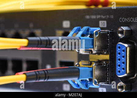 Network optic fiber cables and switch in data center close-up Stock Photo