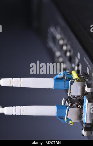 Network devices technology, optical fiber cable and switch, close-up on black background Stock Photo
