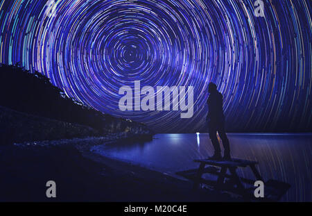 anonymous man enlight the trail of star which shows us to rotation of world Stock Photo