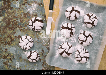 Homemade Chocolate Crinkle Cookies on a baking tray on slate background Stock Photo