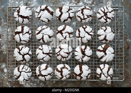 Homemade Chocolate Crinkle Cookies on a cooling rack on slate background Stock Photo