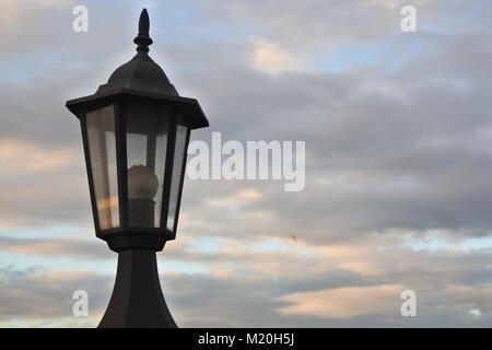 An old lamp post on a cloudy background. Stock Photo