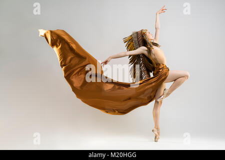 Wild, beautiful american indian woman with big plume of brown feathers. dancing like the spirit of freedom Stock Photo