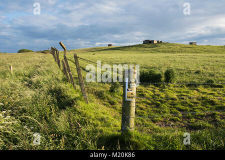 Wire fence surrounds derelict hilltop buildings, remains of RAF Bempton, once a military radar station - Bempton Cliffs, East Yorkshire, England, UK. Stock Photo