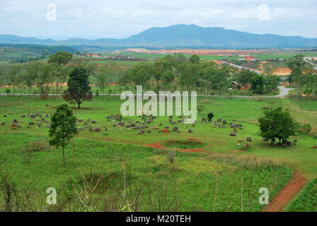 Bomb craters from the Vietnam War surround giant megalithic stone urns at the Plain of Jars archaeological site in Loas. This area is the world's most Stock Photo