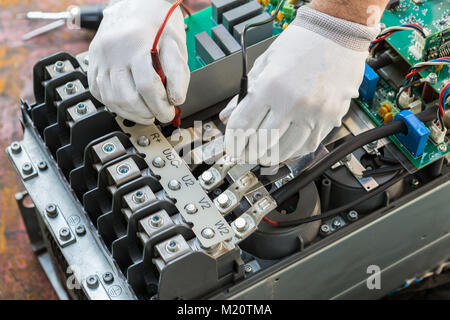 Electrician worker is checking inverter control motor in factory Stock Photo