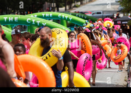 Atlanta, GA, USA - July 15, 2017:  Hundreds of people carry innertube floats as they get in line to participate at Slide the City in Atlanta, GA. Stock Photo