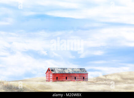 Barn on hill in cloudy field Stock Photo