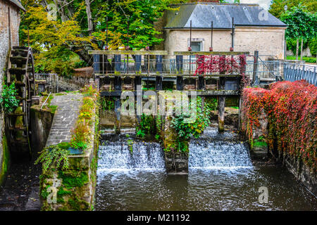 Water mill and Aure River in the old city of Bayeux in Calvados in early autumn with colorful foliage and medieval buildings. Stock Photo