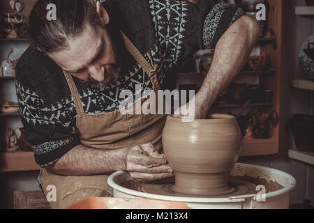 elderly man making pot using pottery wheel in studio Stock Photo