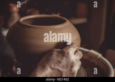 elderly man making pot using pottery wheel in studio Stock Photo