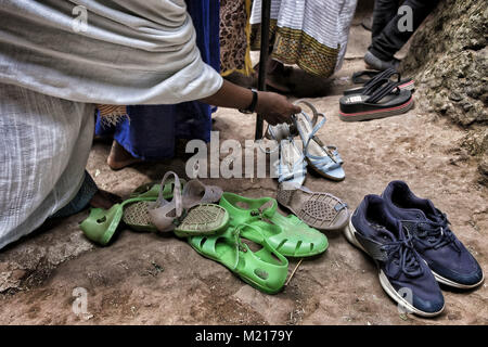 Lalibela, Amhara Region, Ethiopia. 7th Jan, 2018. A woman picking her shoes out of a church in Lalibela.During the first days of January, thousands of Ethiopian Orthodox Christian pilgrims go to the city of Lalibela to visit the ''New Jerusalem''. This holy city is composed of 11 interconnected churches carved by hand that are connected through a series of labyrinths and tunnels.The first days of January mark the celebration of Genna (also known as Ledet), which is the Christmas version of the Ethiopian calendar. During this celebration, the pilgrims travel to the sacred land of Lalibela Stock Photo