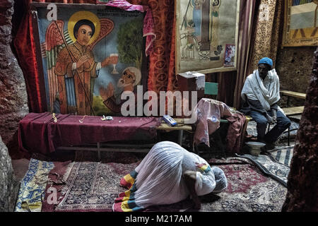 Lalibela, Amhara Region, Ethiopia. 7th Jan, 2018. A woman praying inside a church in Lalibela.During the first days of January, thousands of Ethiopian Orthodox Christian pilgrims go to the city of Lalibela to visit the ''New Jerusalem''. This holy city is composed of 11 interconnected churches carved by hand that are connected through a series of labyrinths and tunnels.The first days of January mark the celebration of Genna (also known as Ledet), which is the Christmas version of the Ethiopian calendar. During this celebration, the pilgrims travel to the sacred land of Lalibela to experi Stock Photo