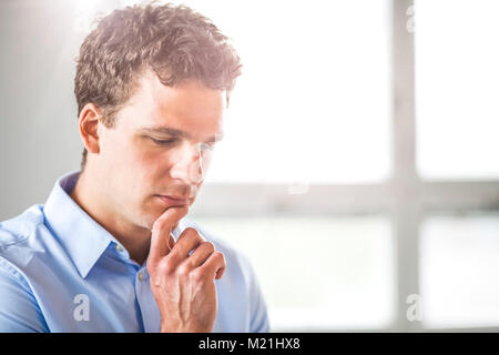 Thoughtful businessman in office Stock Photo