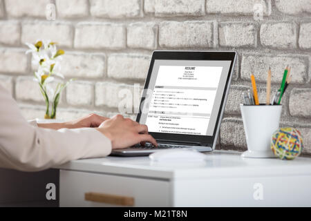 Close-up Of A Business Person Typing Resume On Laptop In Office Stock Photo