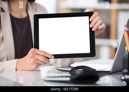 Close-up Of A Businesswoman Showing Digital Tablet With Blank Screen At Workplace In Office Stock Photo