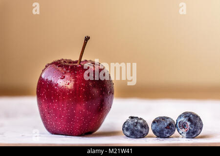 Red apple and tiny blueberries Stock Photo