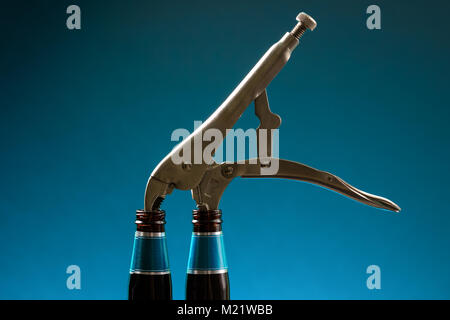 Pliers inserted into two empty bottles. Concept for posters, banners and other design projects. Ideas for advertising projects. Stock Photo