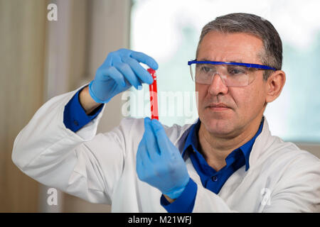 Middle aged scientist wearing protective gear , working in laboratory. Stock Photo