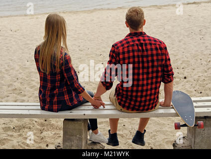 A couple from the back sitting on a bench. Stock Photo