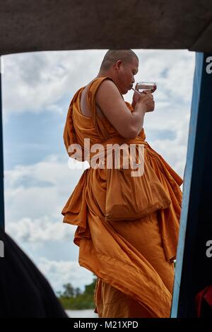 Monk smoking on a boat, Tonlé Sap, Cambodia Stock Photo