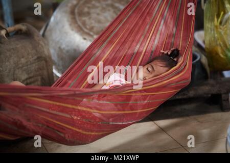 Cambodian little girl sleeping in hammock at local market, Krakor, Cambodia Stock Photo