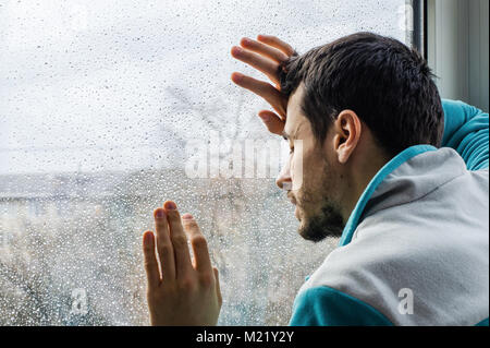 Tired young man suffering from acute pain, male drug addict at rehab clinic Stock Photo
