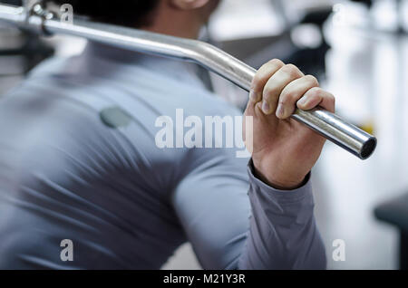 Closeup shot of male hand holding pulldown machine handle, workout in the gym Stock Photo