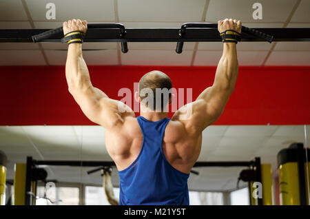 Back view of strong male athlete with perfect muscles training, doing exercises Stock Photo