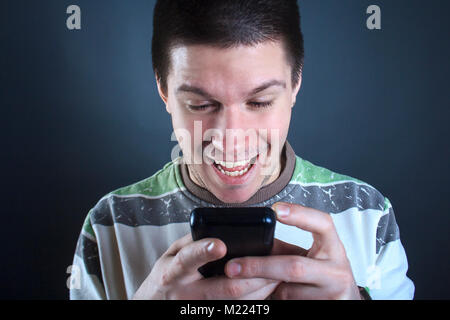 Young man addicted to his smart phone Stock Photo