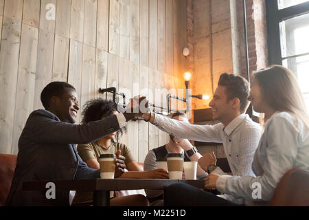African and caucasian men handshaking at coffeehouse meeting wit Stock Photo