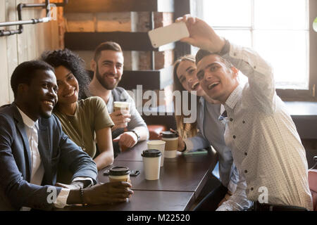 Diverse young friends taking selfie on smartphone together in ca Stock Photo