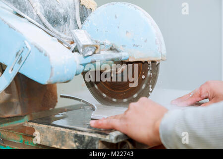 Contractor working on a tile saw The master cuts the tile on the saw Stock Photo