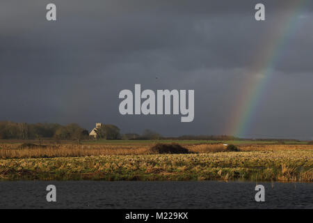 stormy sky with rainbow over marshes  Hempstead marsh, Lessingham, Norfolk, UK         January Stock Photo