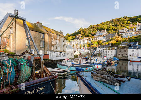 POLPERRO, CORNWALL - JUNE 07, 2009:  Fishing trawlers moored in the pretty Harbour with village seen on the hill behind Stock Photo