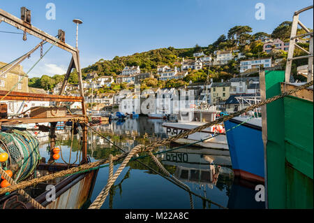 POLPERRO, CORNWALL - JUNE 07, 2009:  Fishing trawlers moored in the pretty Harbour with village seen on the hill behind Stock Photo