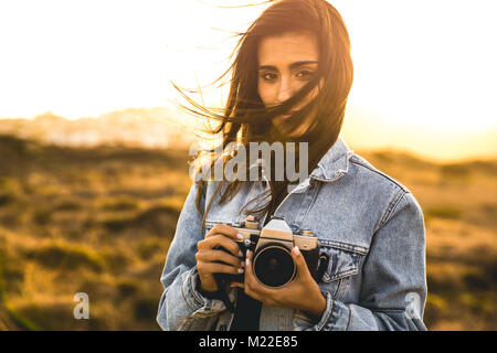 Beautiful woman taking picture outdoors with a analog camera Stock Photo