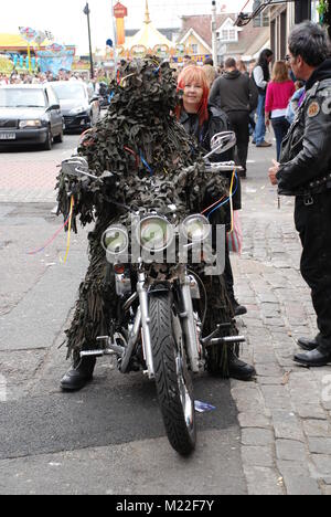 A man in a leaf costume sits on a motorbike during the May Day Jack In The Green festival and separate motorbike rally at Hastings, UK on May 5, 2009. Stock Photo