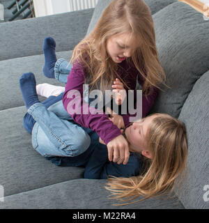 A 7- and a 9-year-old girl scream at each other and beat each other Stock Photo