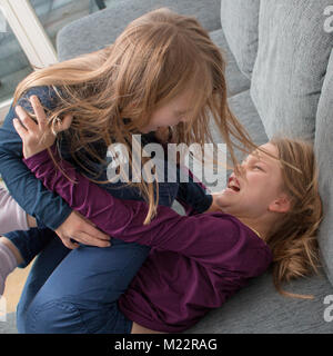 A 7- and a 9-year-old girl scream at each other and beat each other Stock Photo